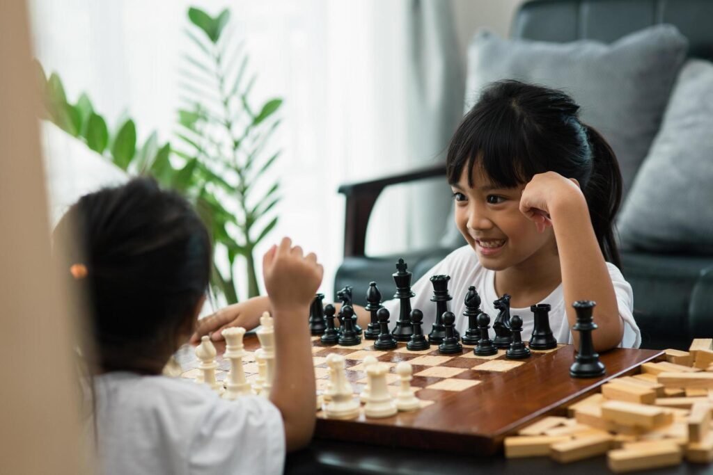 two cute children playing chess at home